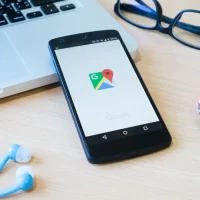 Pessoa navegando em smartphone Android com ícones de redes sociais